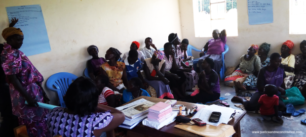 A member of Awee Ikoko Women's Group in Lira demonstrates to her group members how she plans to save money according to the Saving With a Purpose plan.
