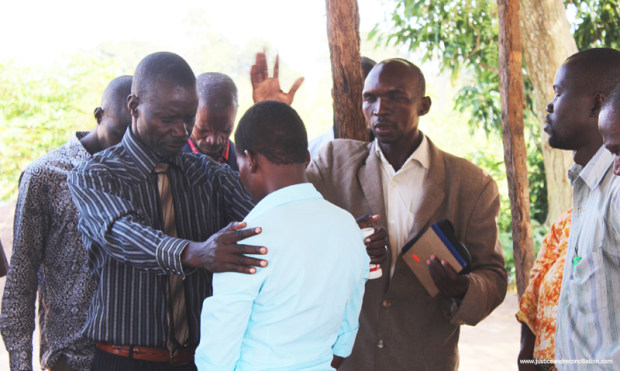 Acen*, a child born into LRA captivity, is received home by her paternal family with prayer in September 2016. Benard Okot/Justice and Reconciliation Project.
