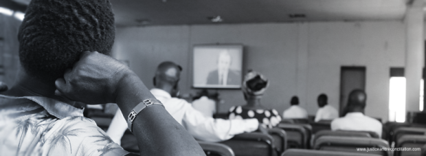 People watch a live screening of Dominic Ongwen's trial at the ICC in Gulu. Oryem Nyeko/JRP.